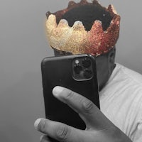 a man taking a selfie with a crown on his head