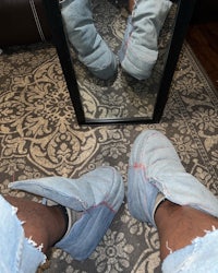 a person standing in front of a mirror wearing a pair of jeans